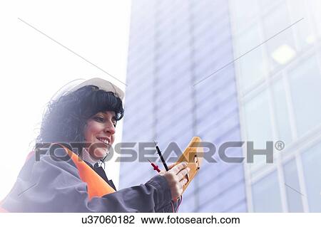 Female surveyor looking at distance meter outside office building View Large Photo Image Stock Image - Female surveyor looking at distance meter outside office building. Fotosearch