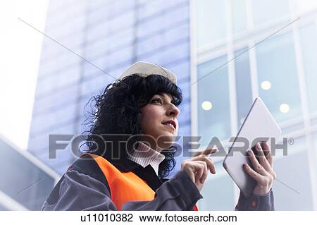 Female surveyor using digital tablet outside office building View Large Photo Image Stock Image - Female surveyor using digital tablet outside office building. Fotosearch