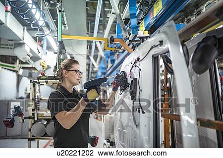 Female worker assembling car doors on production line in a car factory View Large Photo Image Stock Image - Female worker assembling car doors on production line in a car factory. Fotosearch
