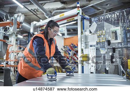 Female worker assembling vehicle roofs in car factory View Large Photo Image Stock Photo - Female worker assembling vehicle roofs in car factory. Fotosearch