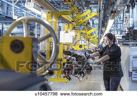 Stock Photo - Female worker on dashboard assembly line in car factory. Fotosearch