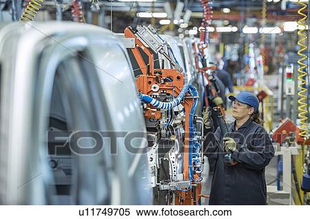 Stock Photography - Female worker on vehicle production line in car factory. Fotosearch