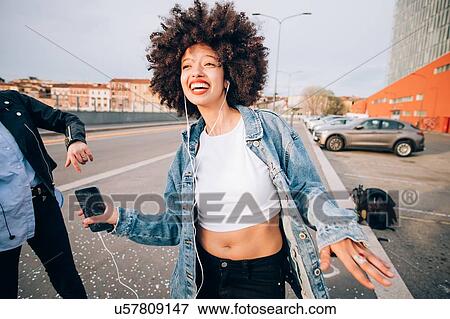 Friends dancing in street to smartphone music, Milan, Italy View Large Photo Image Stock Photo - Friends dancing in street to smartphone music, Milan, Italy. Fotosearch