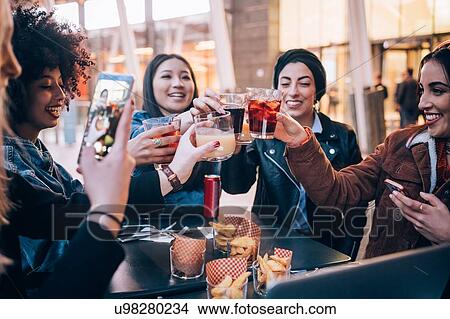 Friends having drinks at outdoor cafe, Milan, Italy View Large Photo Image Picture - Friends having drinks at outdoor cafe, Milan, Italy. Fotosearch