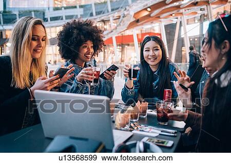 Friends having drinks at outdoor cafe, Milan, Italy View Large Photo Image Stock Photo - Friends having drinks at outdoor cafe, Milan, Italy. Fotosearch