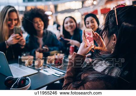Stock Photograph - Friends having drinks at outdoor cafe, Milan, Italy. Fotosearch