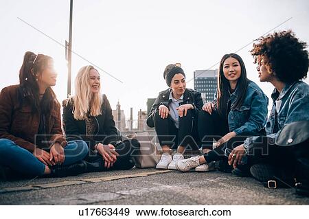 Friends sitting on kerb, Milan, Italy View Large Photo Image Stock Photo - Friends sitting on kerb, Milan, Italy. Fotosearch