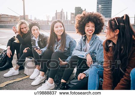 Friends sitting on kerb, Milan, Italy View Large Photo Image Stock Photo - Friends sitting on kerb, Milan, Italy. Fotosearch
