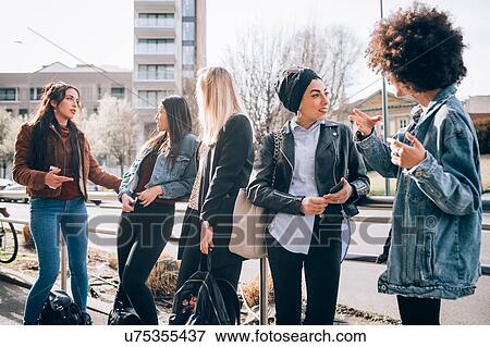 Friends talking in street, Milan, Italy View Large Photo Image Stock Photo - Friends talking in street, Milan, Italy. Fotosearch