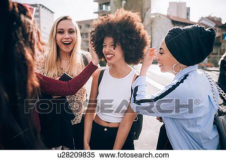 Stock Photography - Friends talking in street, Milan, Italy. Fotosearch