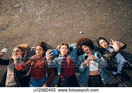 Friends together on kerb taking selfie and using smartphones, Milan, Italy View Large Photo Image Stock Image - Friends together on kerb taking selfie and using smartphones, Milan, Italy. Fotosearch