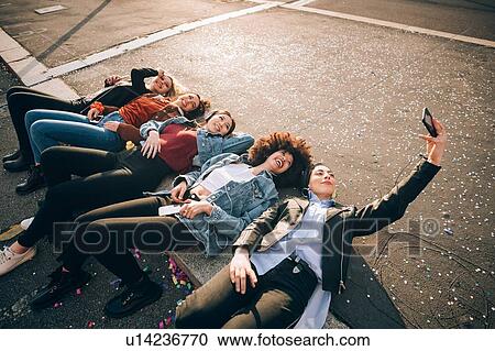 Friends together on kerb taking selfie and using smartphones, Milan, Italy View Large Photo Image Stock Image - Friends together on kerb taking selfie and using smartphones, Milan, Italy. Fotosearch