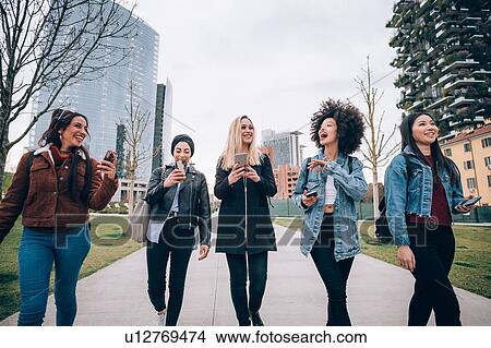 Picture - Friends walking in street, Milan, Italy. Fotosearch