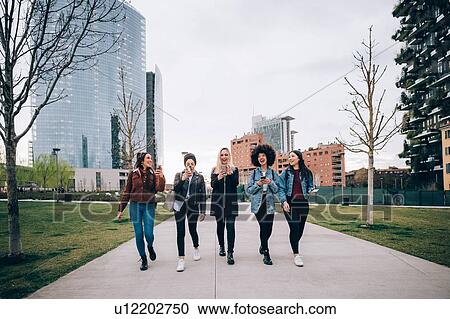 Stock Image - Friends walking in street, Milan, Italy. Fotosearch