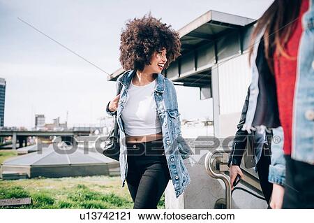 Stock Image - Friends walking in street, Milan, Italy. Fotosearch