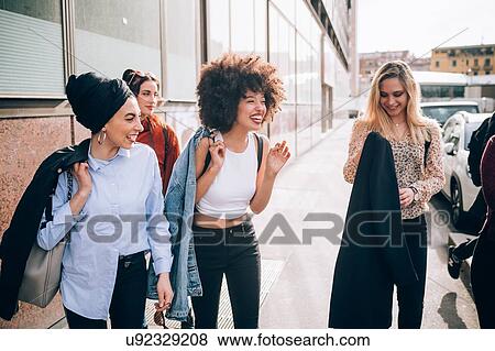 Stock Photo - Friends walking in street, Milan, Italy. Fotosearch