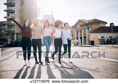 Stock Photograph - Friends walking in street, Milan, Italy. Fotosearch