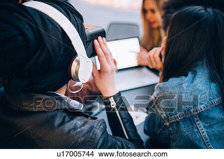 Picture - Friends working on virtual reality project at outdoor cafe, Milan, Italy. Fotosearch