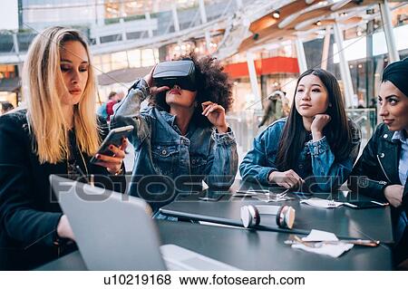Friends working on virtual reality project at outdoor cafe, Milan, Italy View Large Photo Image Stock Photo - Friends working on virtual reality project at outdoor cafe, Milan, Italy. Fotosearch