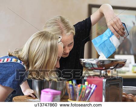 Girl and her sister baking a cake, weighing flour on kitchen scales View Large Photo Image Stock Image - Girl and her sister baking a cake, weighing flour on kitchen scales. Fotosearch
