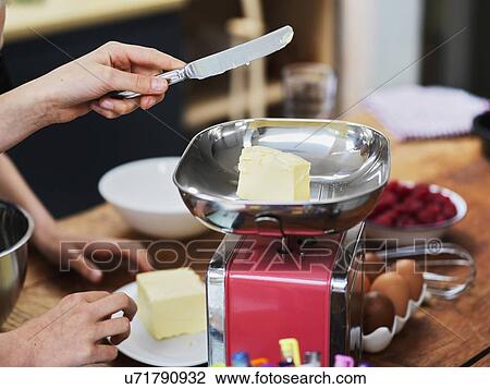 Girl and her sister baking a cake, weighing butter on kitchen scales, cropped view of hands View Large Photo Image Stock Image - Girl and her sister baking a cake, weighing butter on kitchen scales, cropped view of hands. Fotosearch