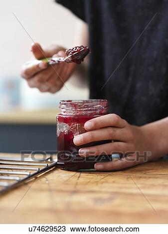 Girl baking a cake, holding spoonful of jam at kitchen table, close up of hands View Large Photo Image Stock Image - Girl baking a cake, holding spoonful of jam at kitchen table, close up of hands. Fotosearch