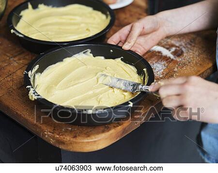 Girl baking a cake, smoothing cake mixture in cake tin at kitchen table, cropped close up of hands View Large Photo Image Stock Image - Girl baking a cake, smoothing cake mixture in cake tin at kitchen table, cropped close up of hands. Fotosearch