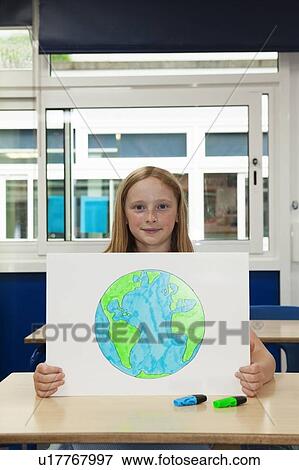 Girl holding up placard with a drawing of the Earth View Large Photo Image Stock Photo - Girl holding up placard with a drawing of the Earth. Fotosearch