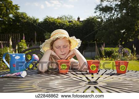 Stock Image - Girl looking at flower pots. Fotosearch