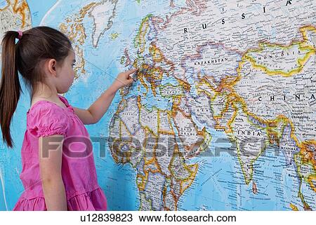 Stock Image - Girl looking at map of Europe. Fotosearch