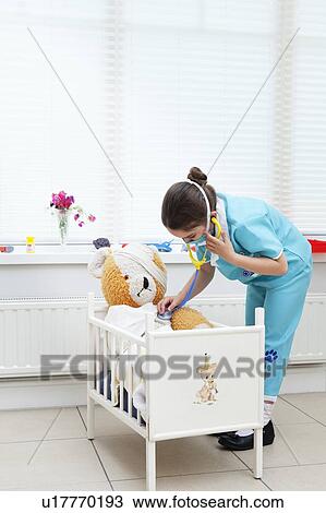 Stock Image - Girl nursing her teddy bear. Fotosearch