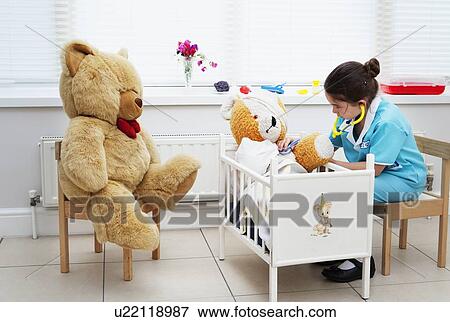 Stock Photo - Girl nursing her teddy bear. Fotosearch