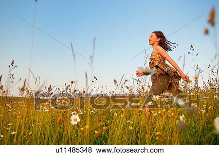 Girl running through wildflower meadow View Large Photo Image Stock Photo - Girl running through wildflower meadow. Fotosearch