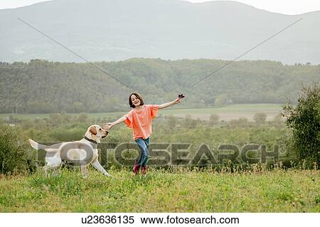 Girl running with labrador dog in scenic field landscape, Citta della Pieve, Umbria, Italy View Large Photo Image Stock Photography - Girl running with labrador dog in scenic field landscape, Citta della Pieve, Umbria, Italy. Fotosearch