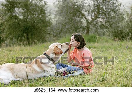 Girl sitting face to face with labrador dog in field landscape, Citta della Pieve, Umbria, Italy View Large Photo Image Picture - Girl sitting face to face with labrador dog in field landscape, Citta della Pieve, Umbria, Italy. Fotosearch