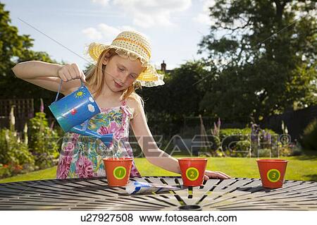 Stock Photo - Girl watering flower pots. Fotosearch