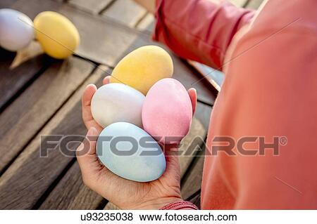 Girl with a handful of dyed Easter eggs at table, cropped over shoulder view View Large Photo Image Stock Photo - Girl with a handful of dyed Easter eggs at table, cropped over shoulder view. Fotosearch