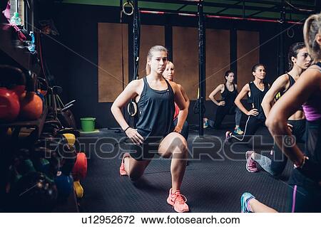 Stock Image - Group of women training in gym, stretching with hands on hips. Fotosearch