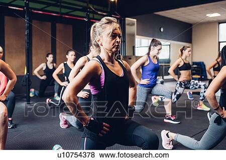 Stock Photo - Group of women training in gym, stretching with hands on hips. Fotosearch