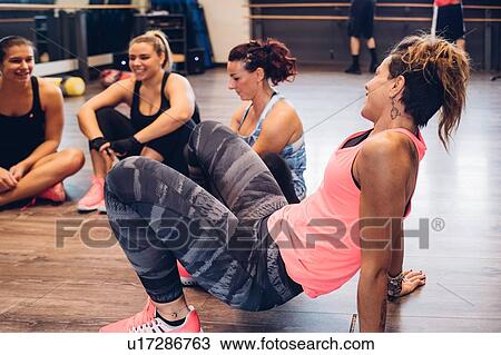 Group of women training in gym, taking a break sitting on floor View Large Photo Image Stock Image - Group of women training in gym, taking a break sitting on floor. Fotosearch