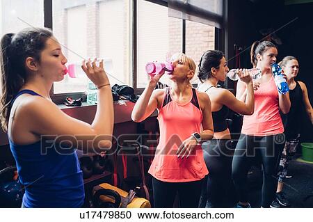 Group of women training in gym, taking a break drinking bottled water View Large Photo Image Stock Image - Group of women training in gym, taking a break drinking bottled water. Fotosearch