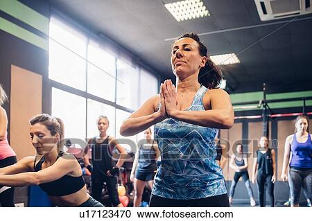 Stock Image - Group of women training in gym, with hands together. Fotosearch