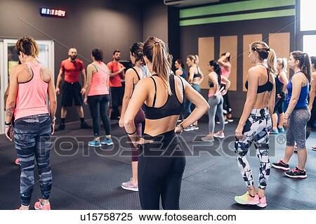 Stock Photography - Group of women training in gym with male trainers. Fotosearch