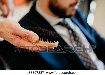 Hairdresser preparing to brush customer's beard in barber shop View Large Photo Image Stock Photo - Hairdresser preparing to brush customer's beard in barber shop. Fotosearch