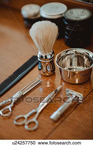 Stock Image - Hairdressing and shaving tools on table. Fotosearch