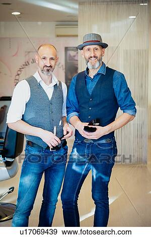 Stock Photo - Happy business partners in barber shop. Fotosearch
