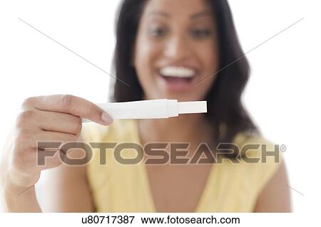 Happy woman looking at pregnancy test View Large Photo Image Stock Photo - Happy woman looking at pregnancy test. Fotosearch