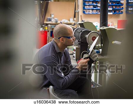Knife factory worker examining knife blade in workshop View Large Photo Image Stock Photo - Knife factory worker examining knife blade in workshop. Fotosearch