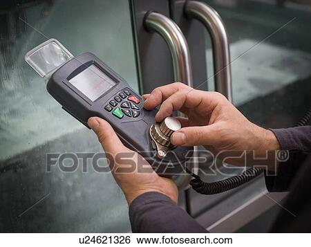 Stock Photograph - Knife factory worker operating machinery controls, close up of hands. Fotosearch