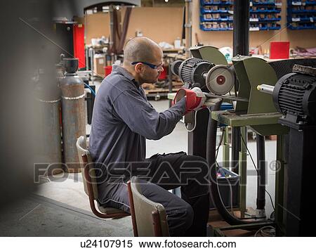Stock Photography - Knife factory worker using angle grinder in workshop. Fotosearch